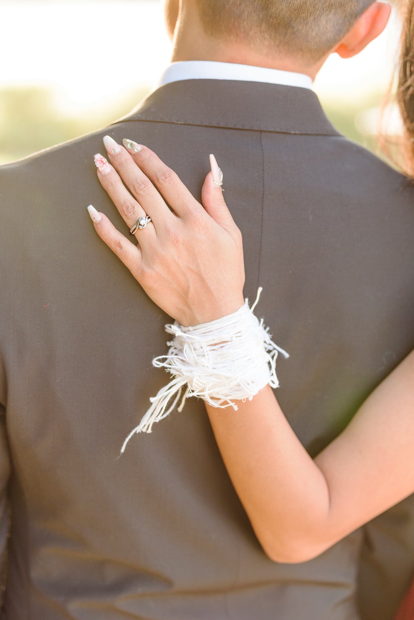 The bride's wrist has hundreds of white strings tied around it during their Hmong ceremony.
